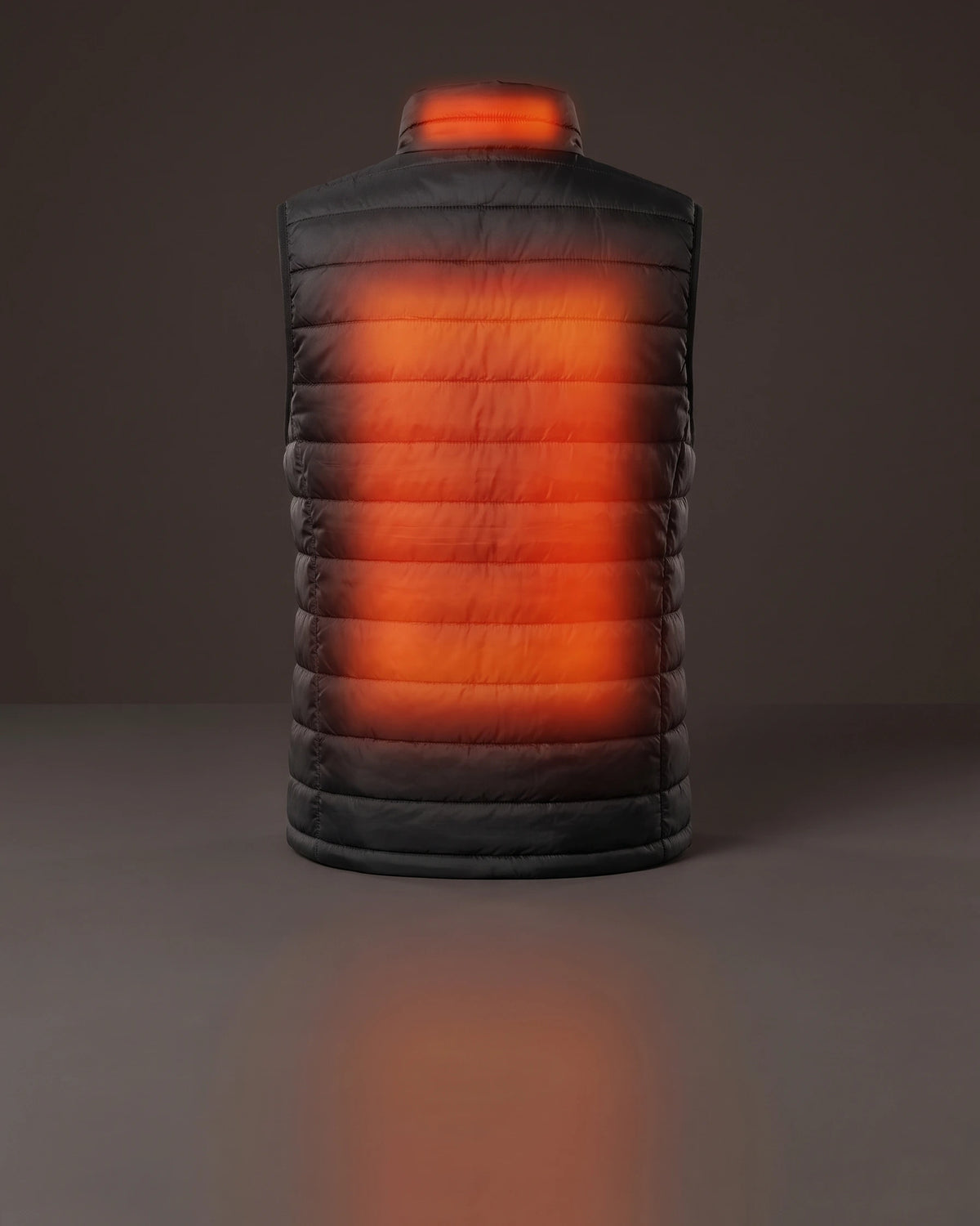 The black HeatGuard heated vest seen from behind, its back and collar glowing red